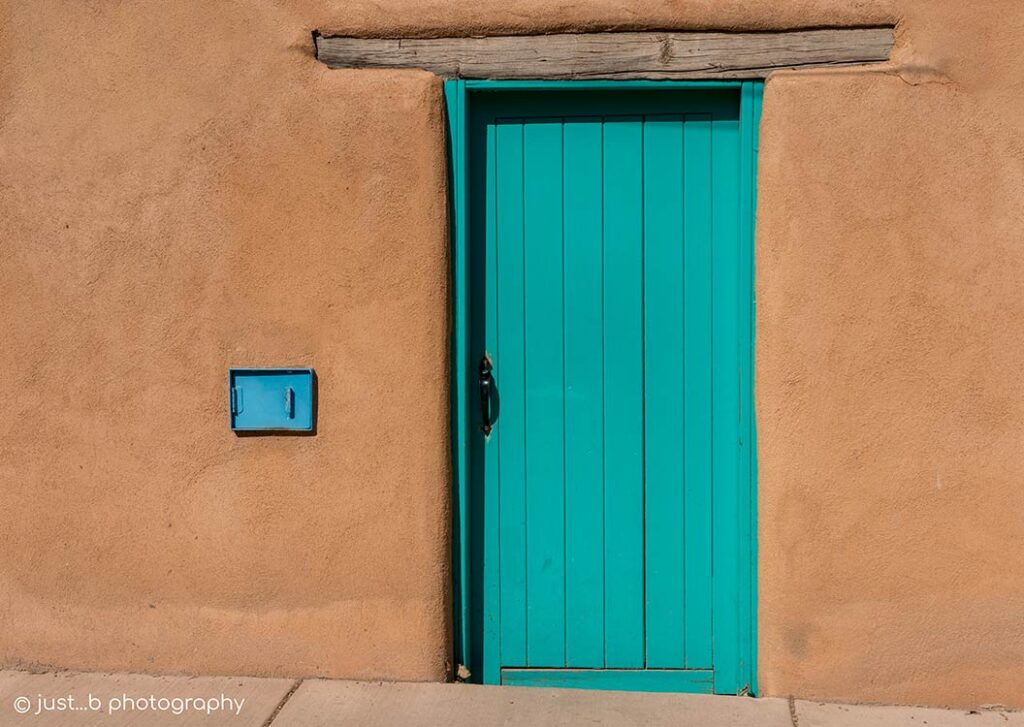 Turquoise painted door in adobe structure.