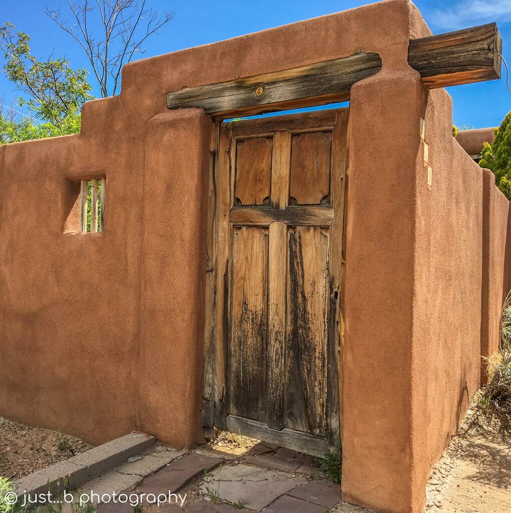 Wooden door with wood beam in adobe walls