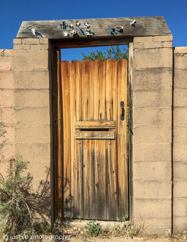 Wooden slats door in adobe brick wall.