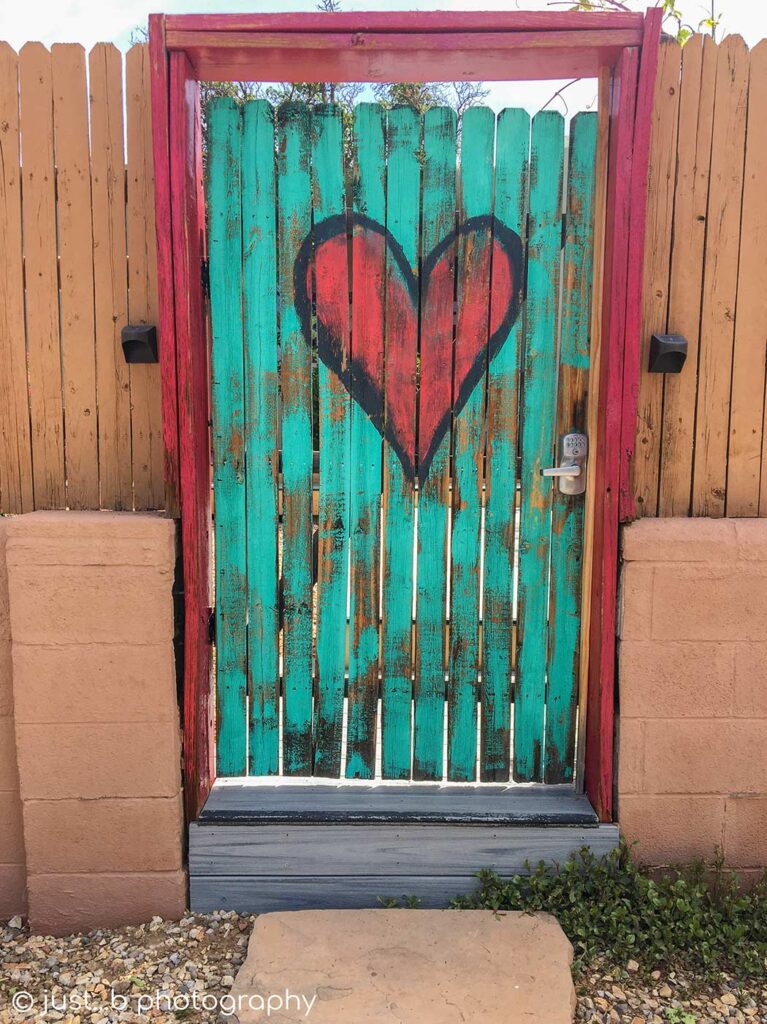 Turquoise blue door with big red heart.