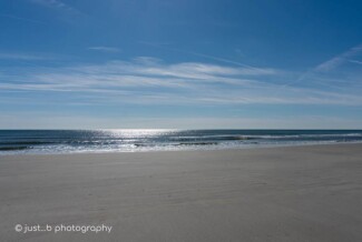Calm Atlantic ocean at low tide on a sunny, cold winter day.